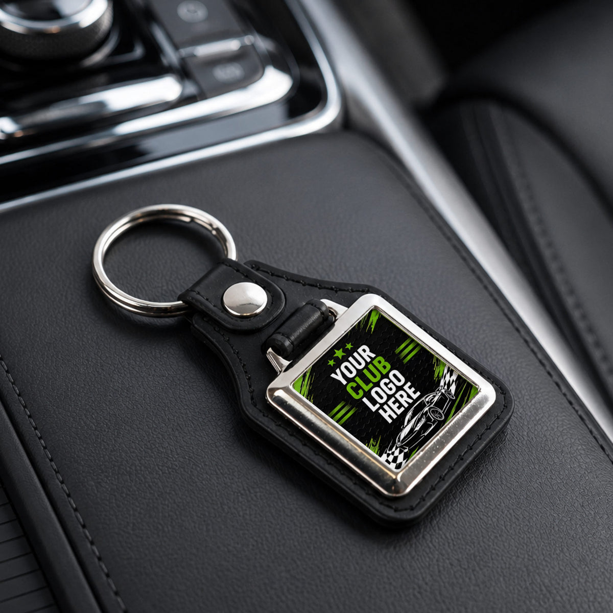Personalised square leather and metal car club keyring on a modern car centre console.