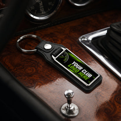 Personalised long rectangle leather and metal car club keyring on a classic car centre console.