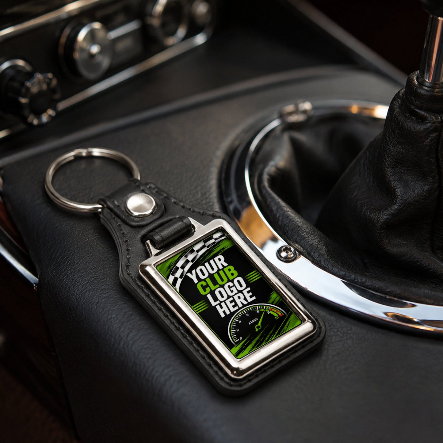 Personalised rectangle leather and metal car club keyring on a modern car centre console.