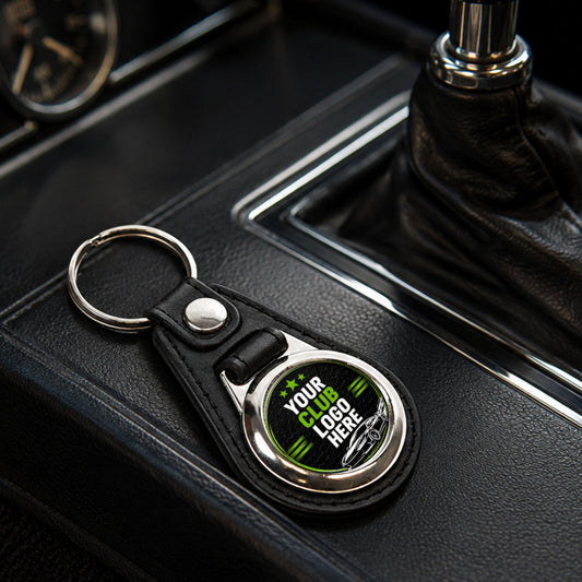 Personalised round leather and metal car club keyring on a modern car centre console.