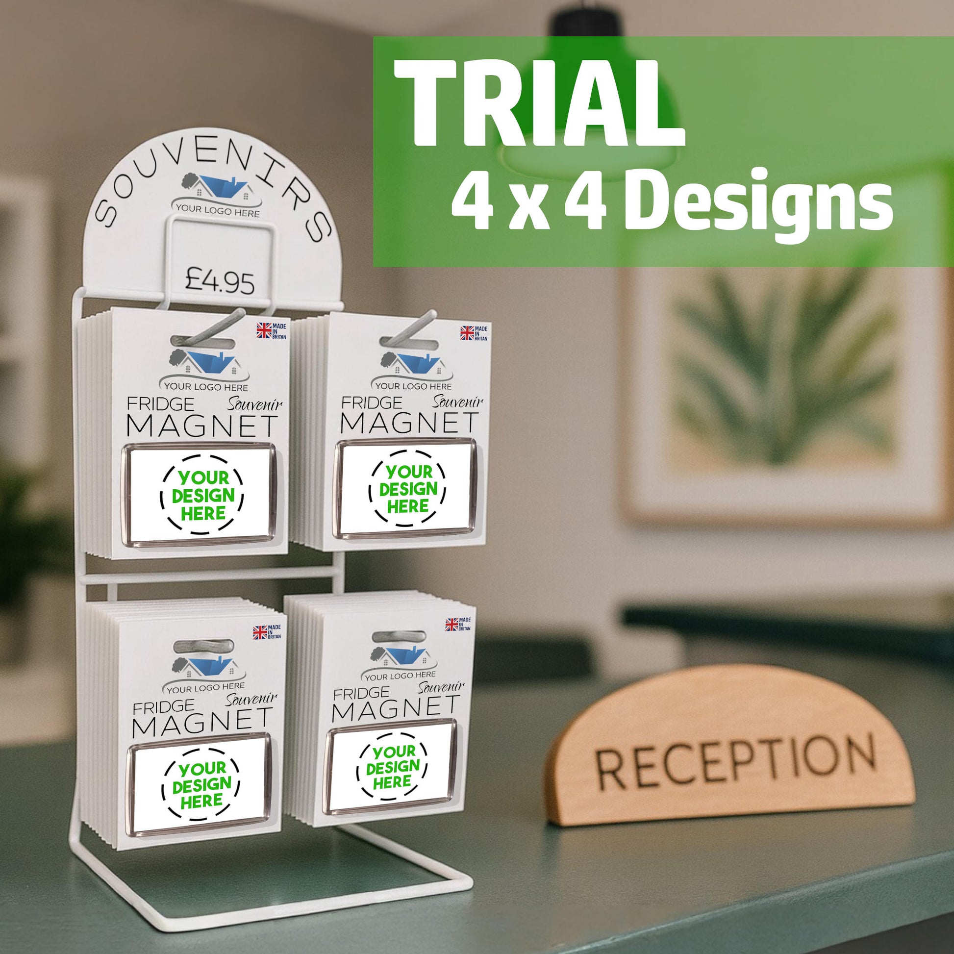 Snazzy Frog Shop in a Box trial-size souvenir display stand on a reception counter, holding fridge magnets with placeholder designs and your logo here branding.